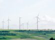 Multiple wind turbines in a flat grassy field